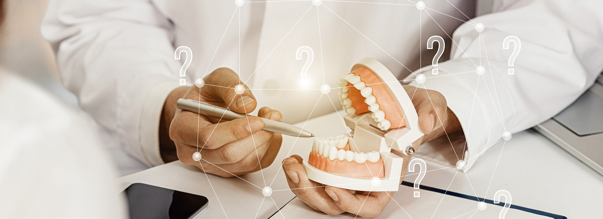 The image is a photograph of a dental professional holding a set of dentures with a digital overlay that includes a schematic representation of a mouth and teeth, along with various numbers and symbols.