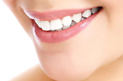 The image shows a close-up of a person s face with a focus on their teeth, which are highlighted by a bright smile.